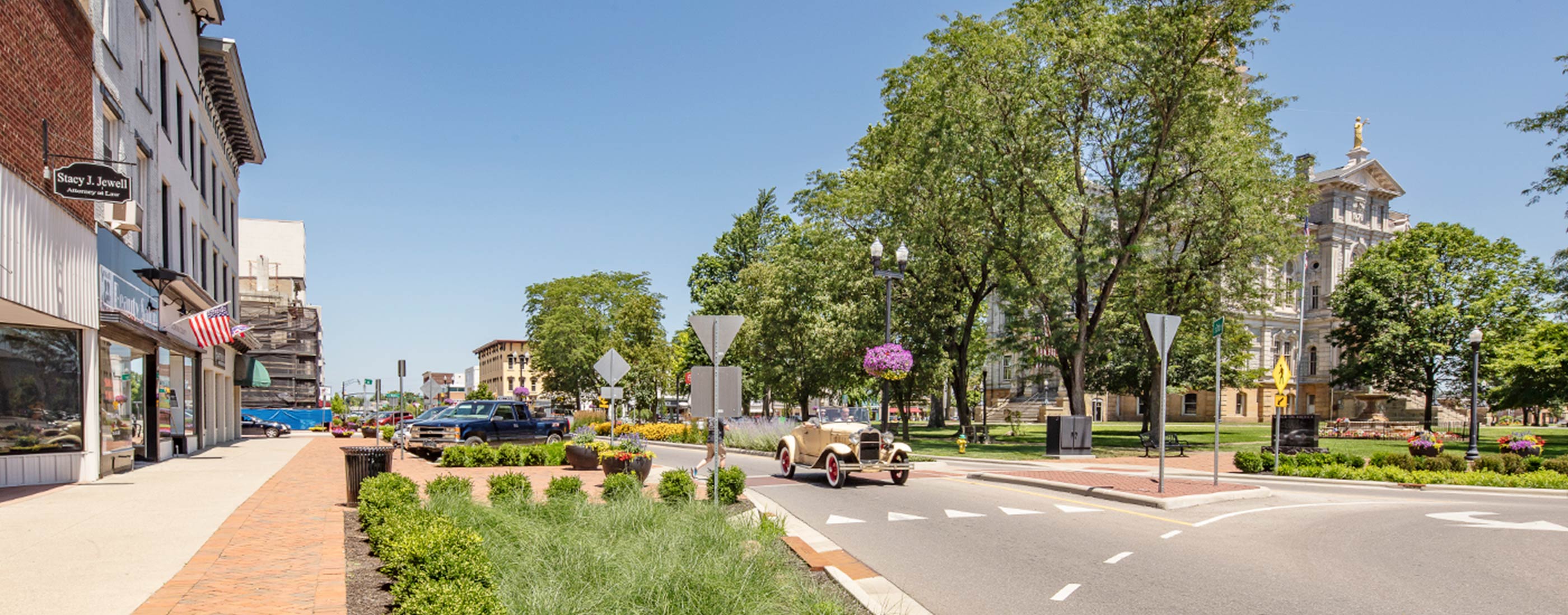 An old car drives through Newark, Ohio's roundabout and streetscape.