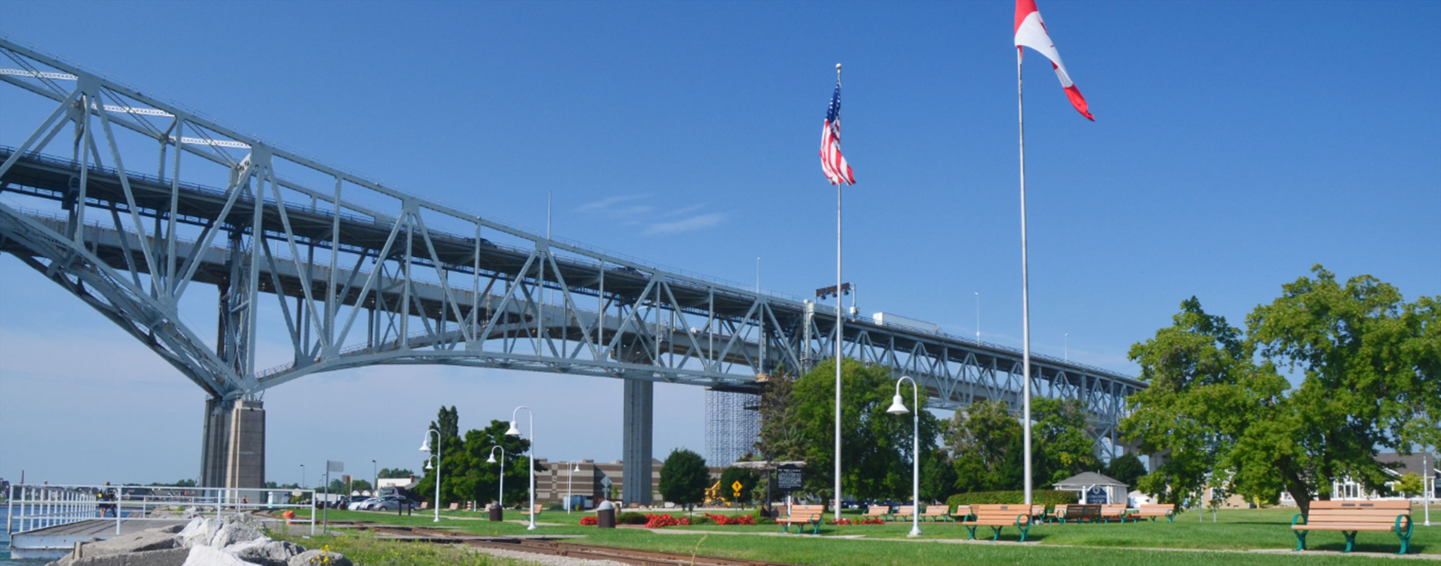 Canadian and American flags wave near the Blue Water Bridge.