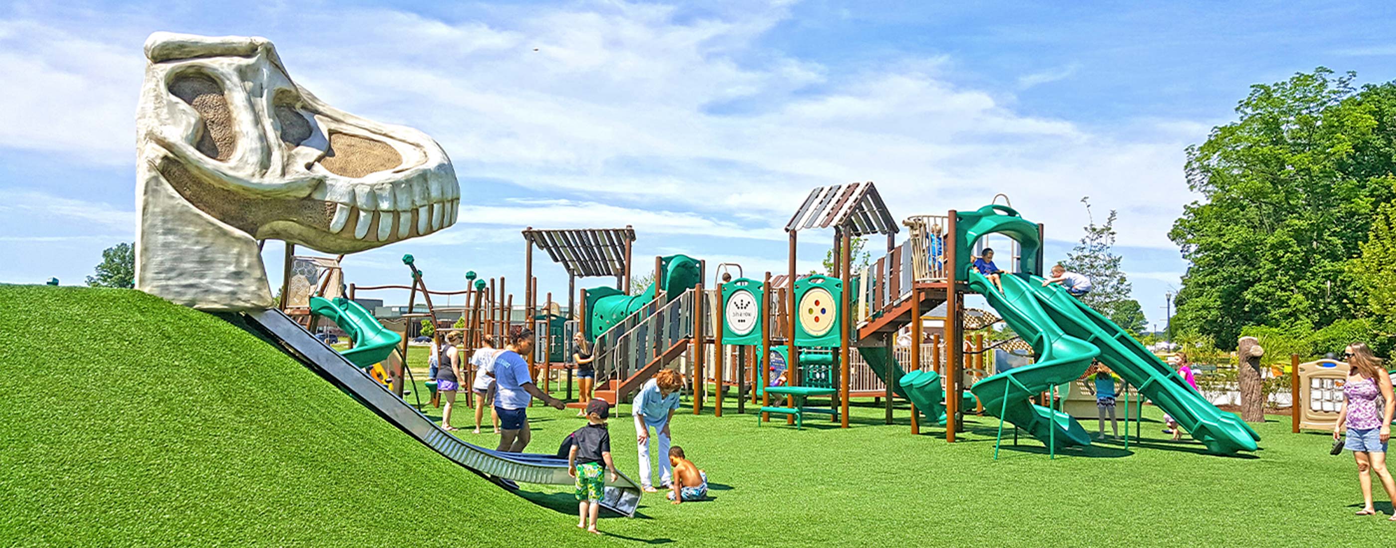 Children play on a dinosaur slide at the Veterans Memorial Park.