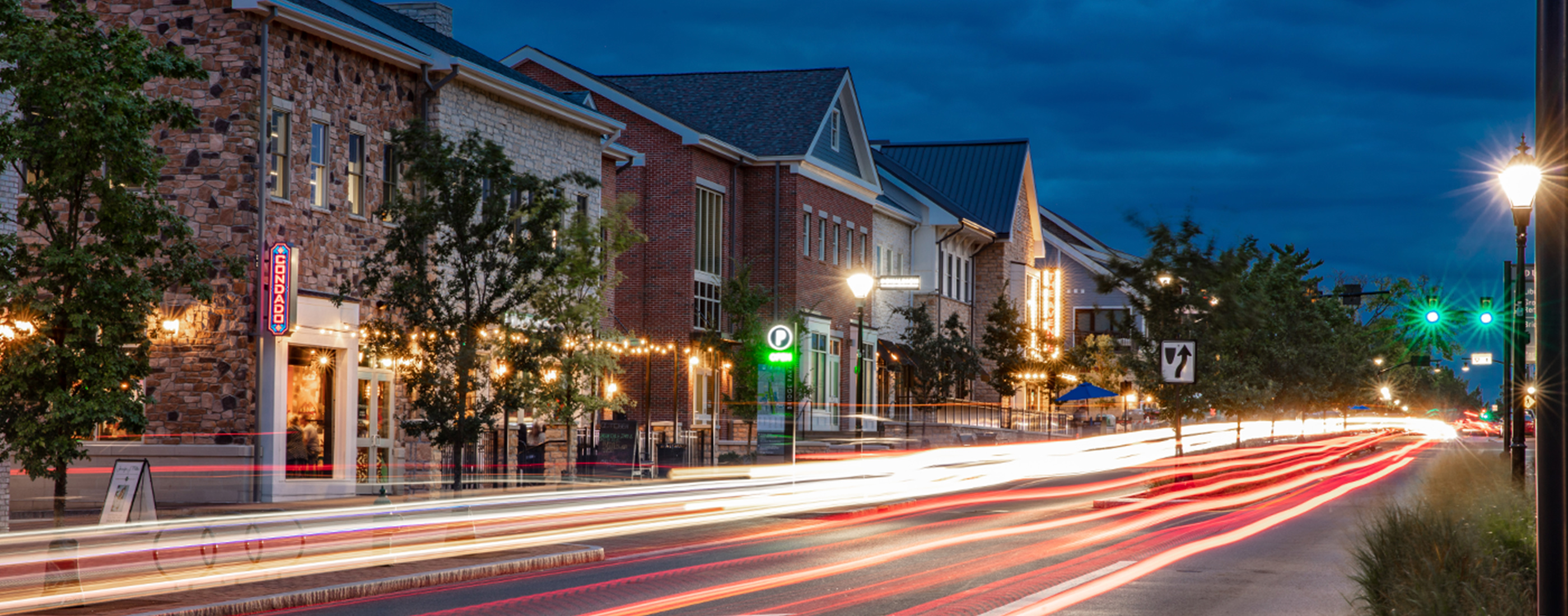 The City of Dublin, Ohio's Bridge Park West streetscape lit up at night.