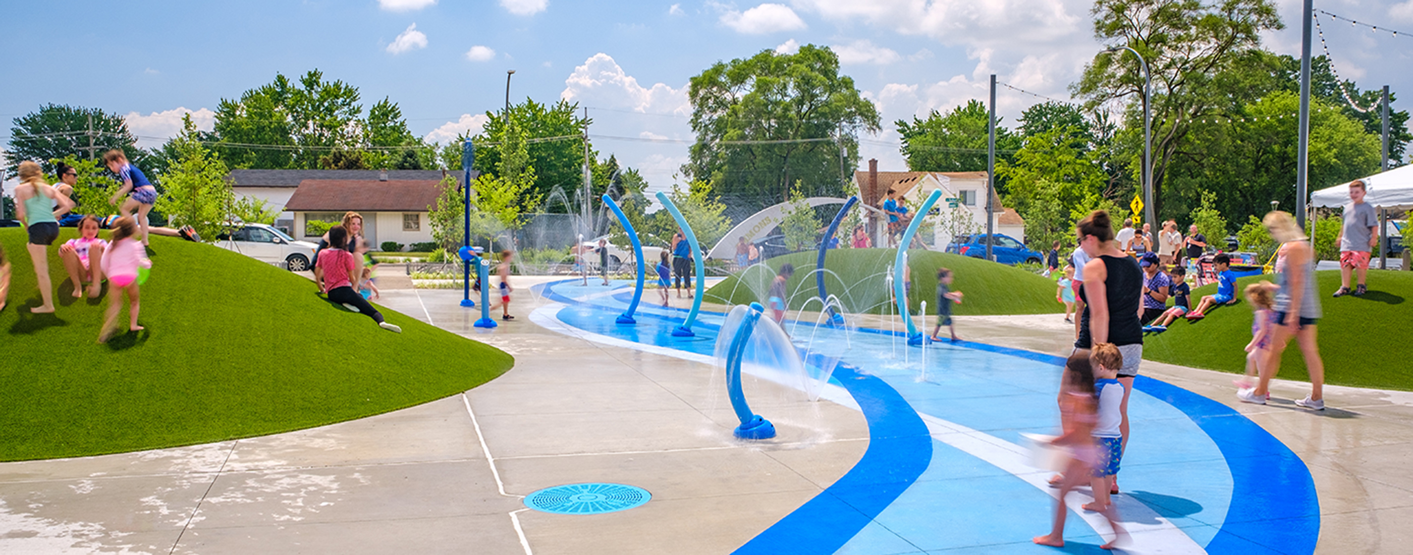 Families enjoying the new spray park at Emmons Plaza on Auburn Road.