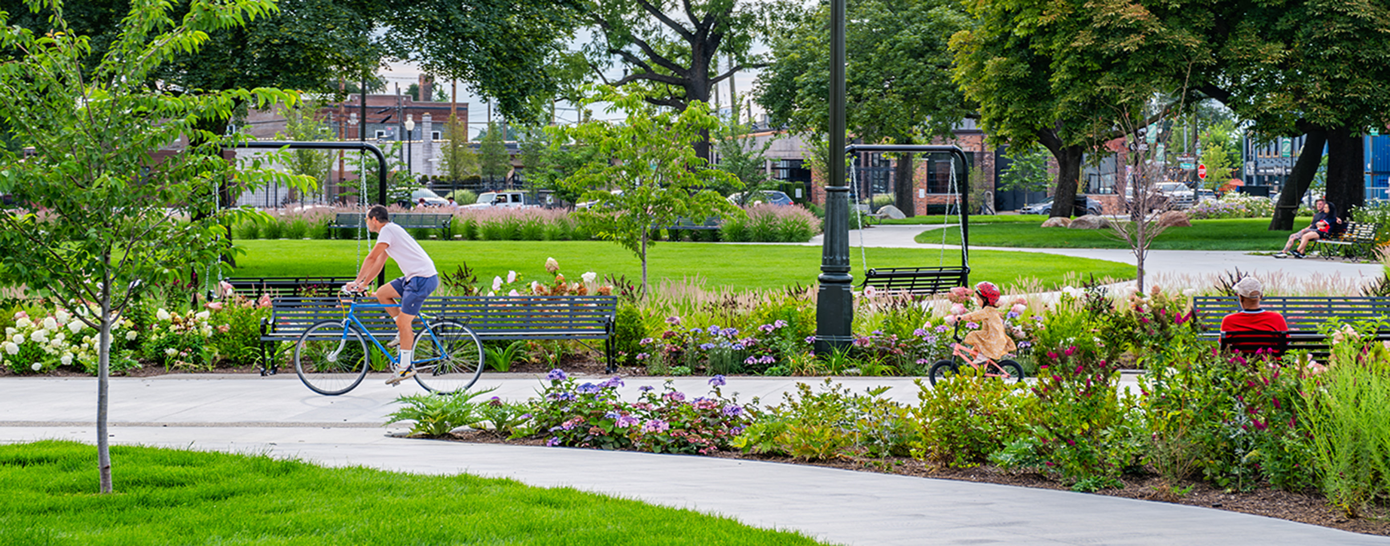 Cyclists use the multiuse pathways in Roosevelt Park on a sunny day.