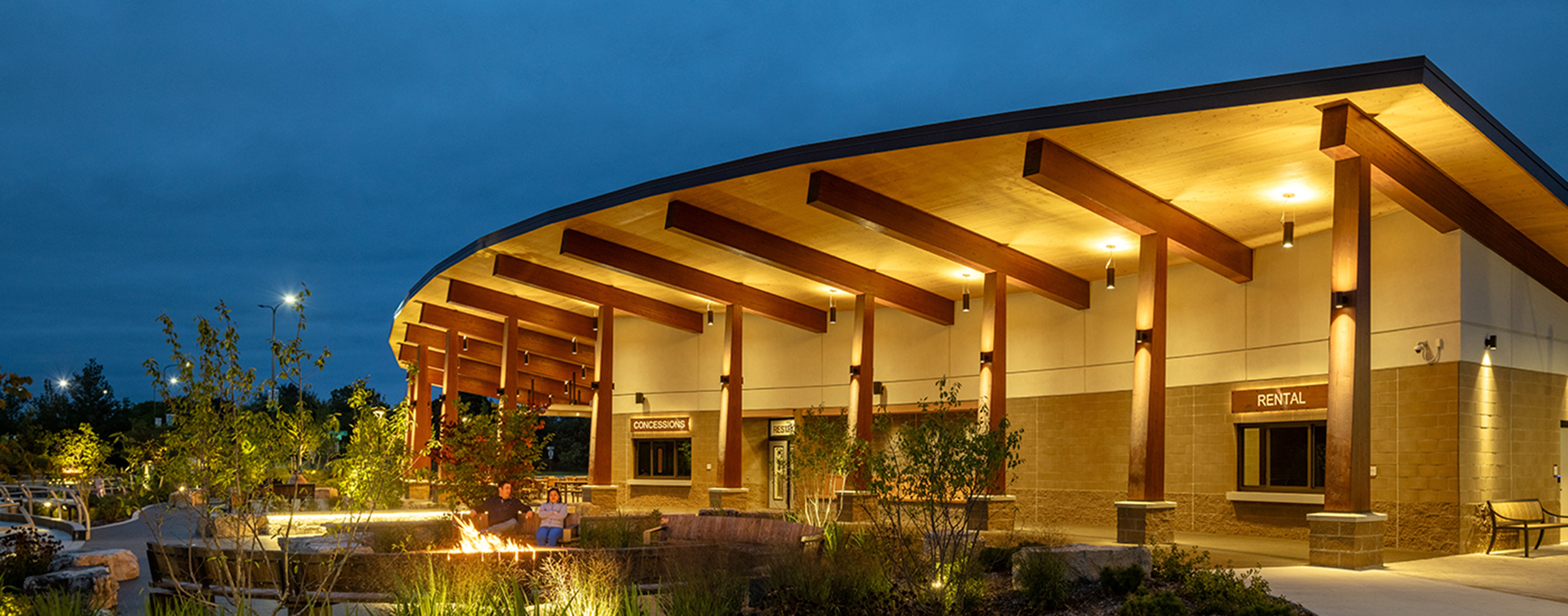Night shot of mass timber pavilion and seating at Jeanne Stine Park in Troy, Michigan.