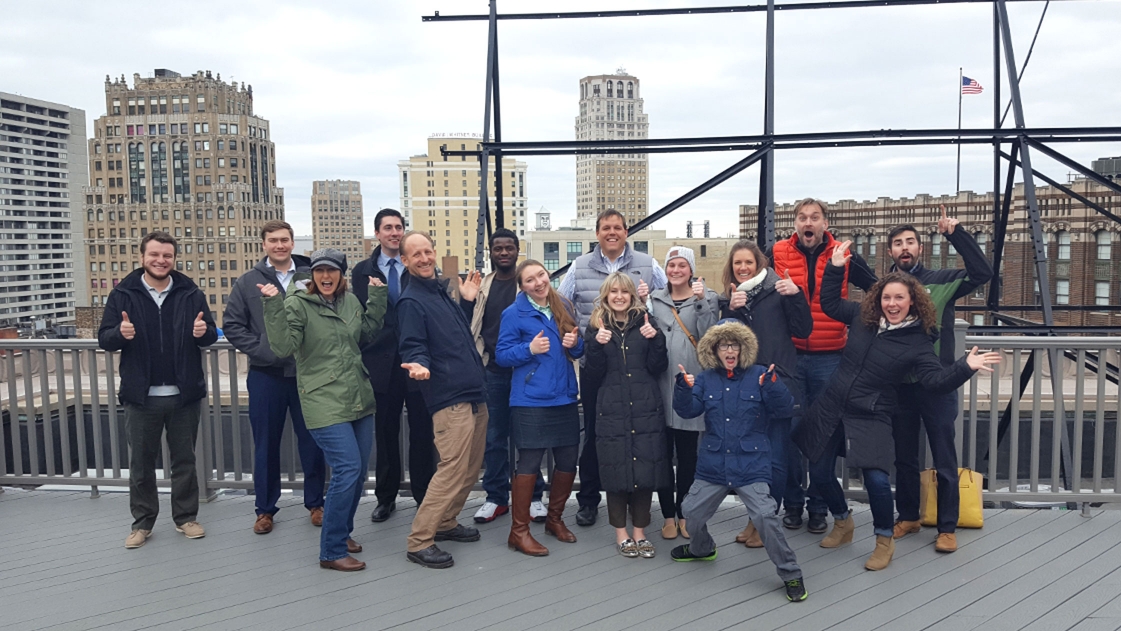 A group of OHM Advisors employees pose on a Detroit roof.