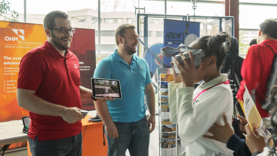 Mike Cousins, GIS Practice Leader, interacts with students at the Construction Science Expo.