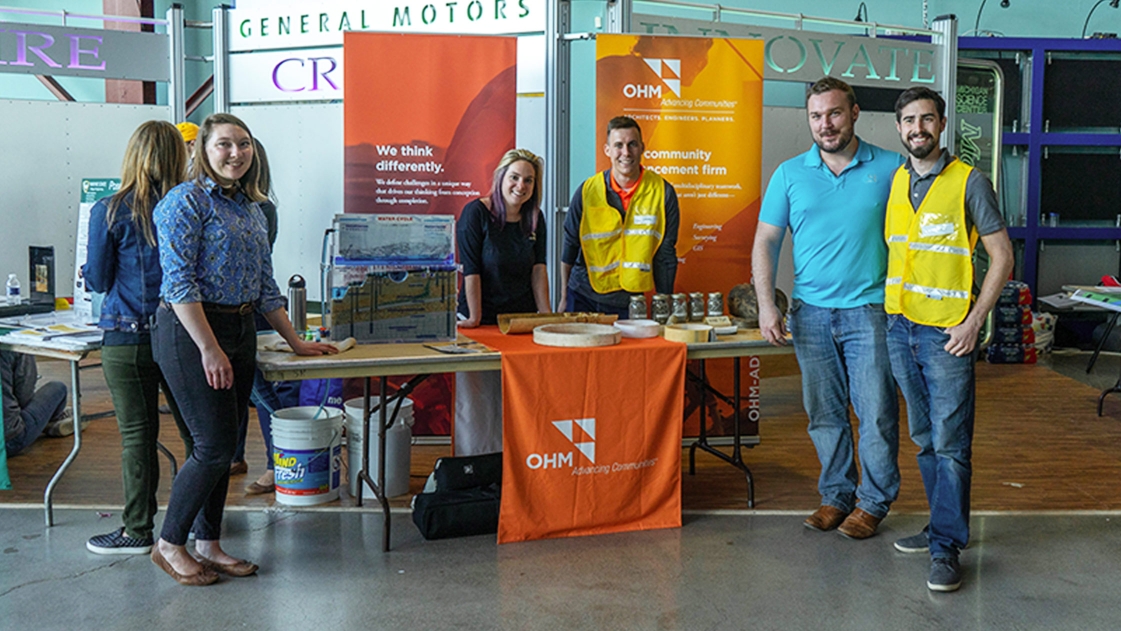 A team of employees stand ready to discuss Advancing Communities at the Construction Science Expo.