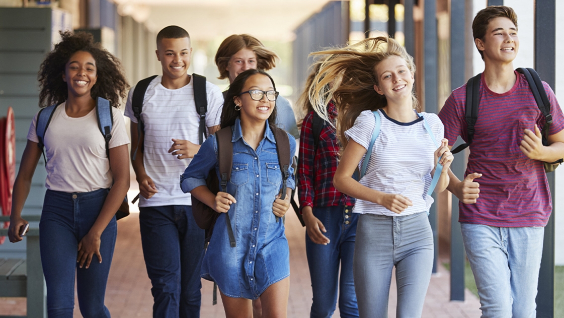Young teenagers walk through a school designed with security.