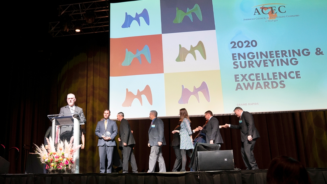 OHM Advisors team members step onstage to accept the 2020 Firm of the Year Award from ACEC Michigan