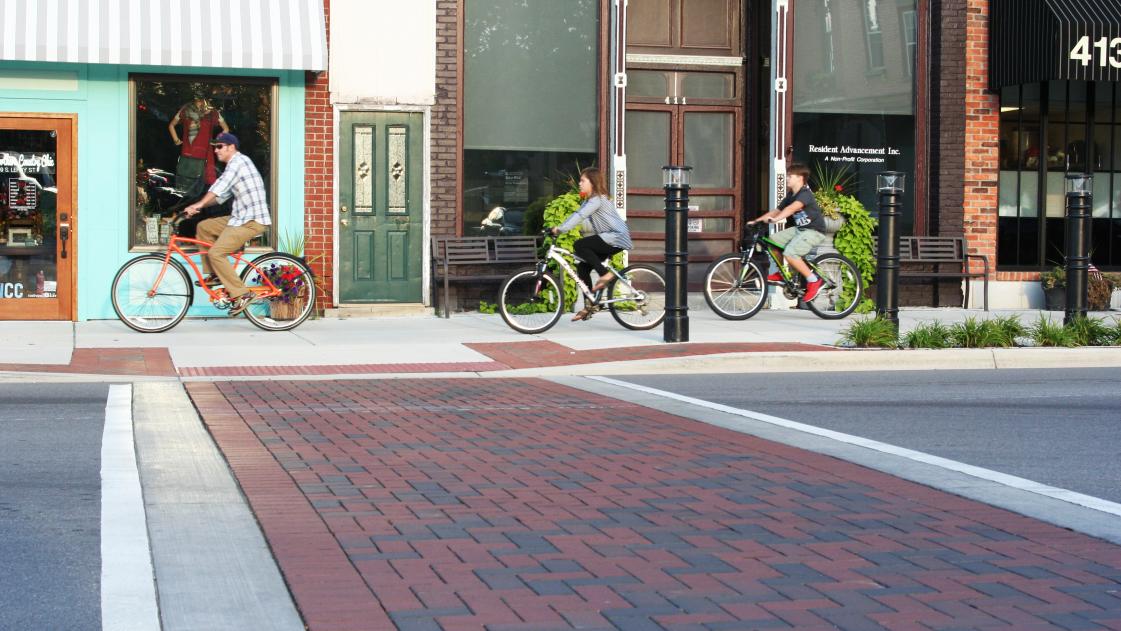 Pedestrians ride their bicycles throughout the Downtown Fenton Streetscape.