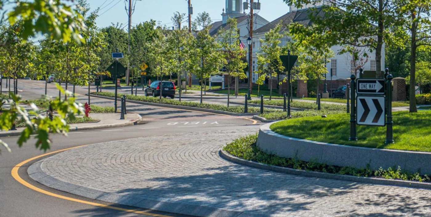 The center of New Albany, Ohio central roundabout, designed by OHM Advisors, is anchored by trees and a low granite wall.