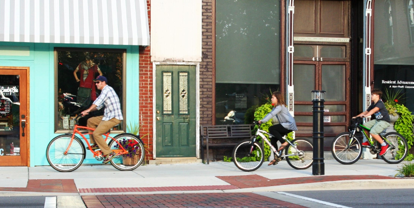 A family enjoys a bike ride along Fenton, Michigan’s new downtown streetscape, a project led by OHM Advisors.