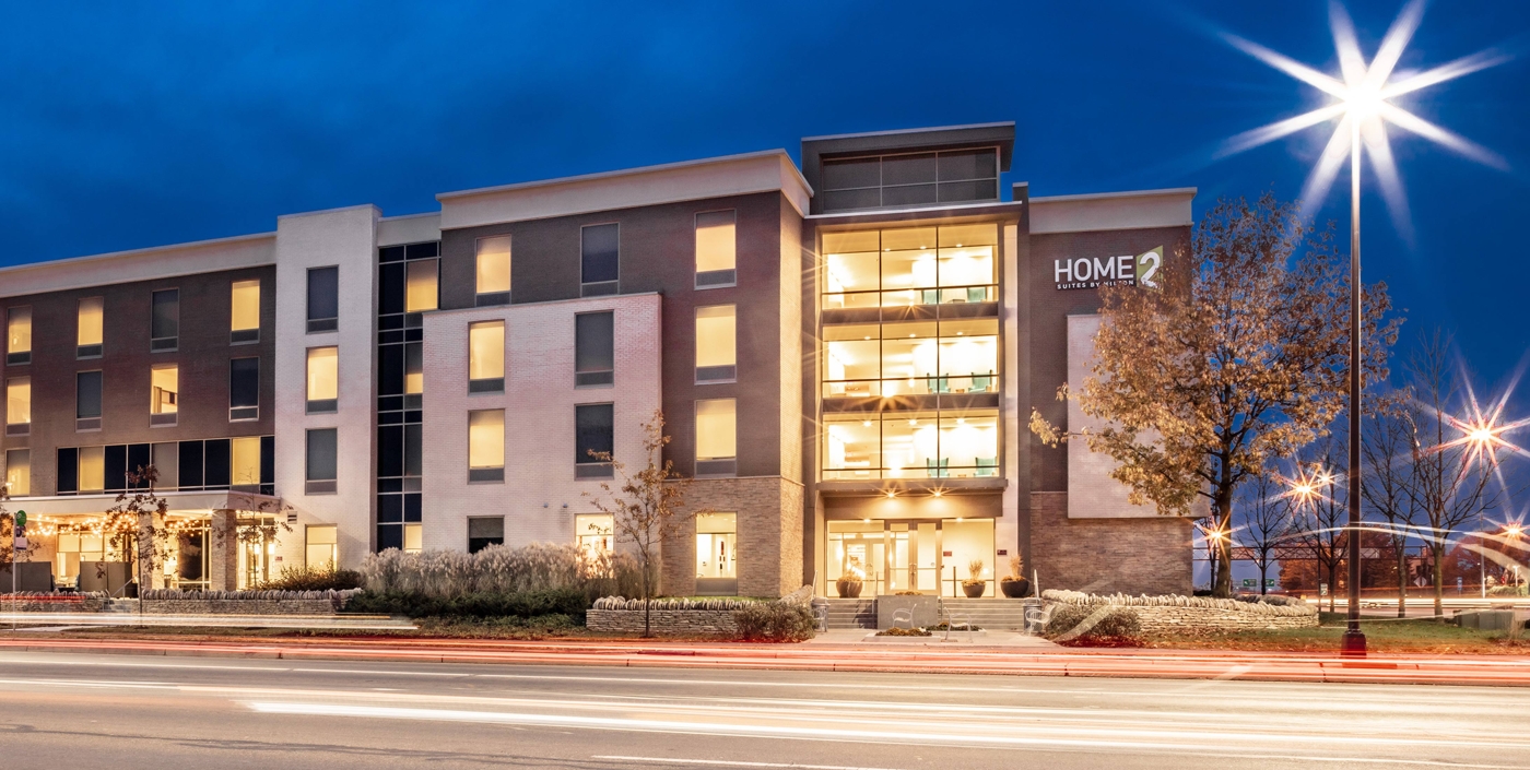 A nighttime view of the modern Hilton HOME2 Hotel, designed by OHM Advisors.