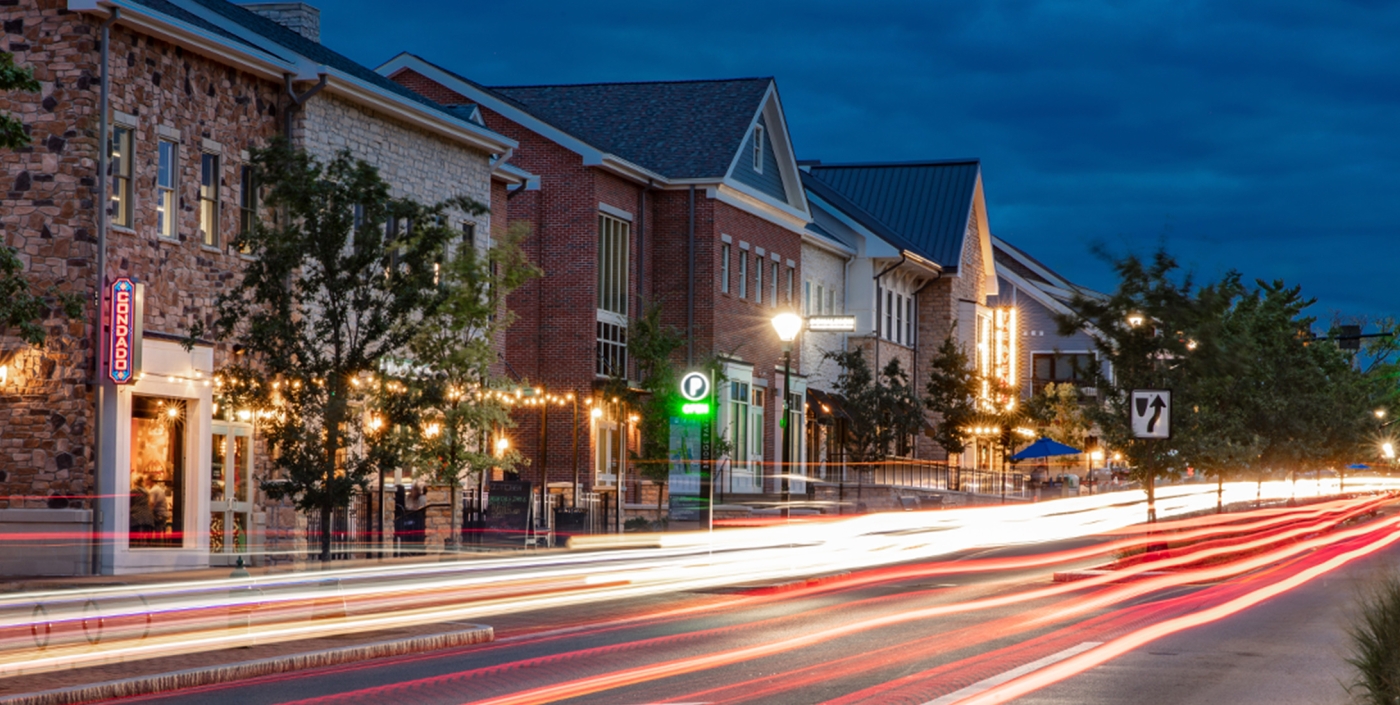 The City of Dublin, Ohio's Bridge Park West streetscape lit up at night.