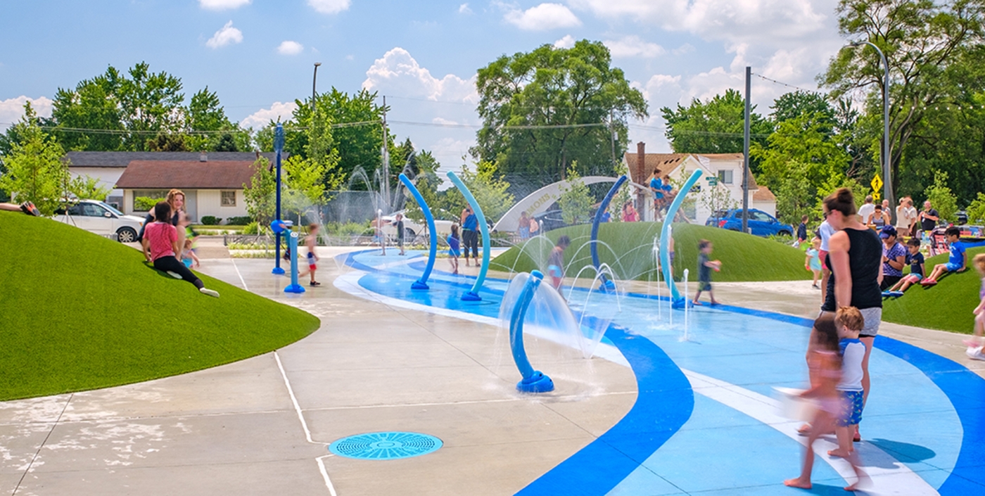 Families enjoying the new spray park at Emmons Plaza on Auburn Road.