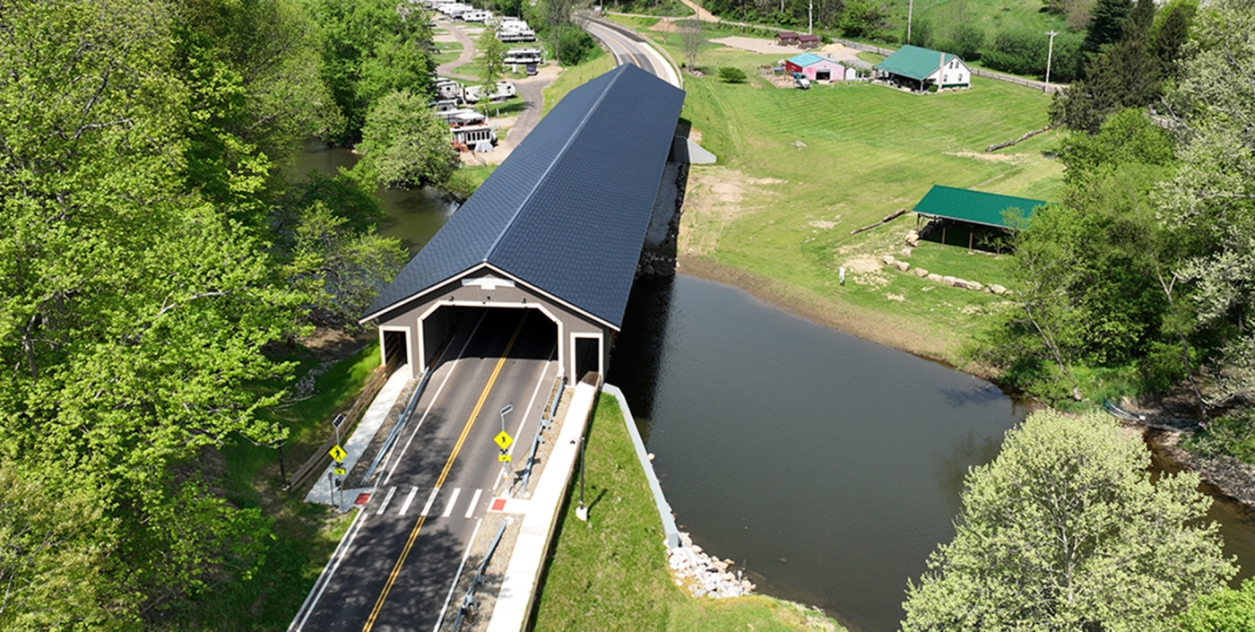 Two-lane covered timber bridge over the Mohican River.