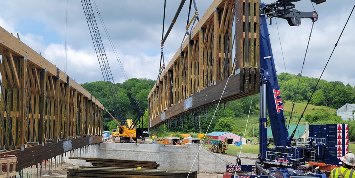 Crane moves wood structure into place during bridge construction 