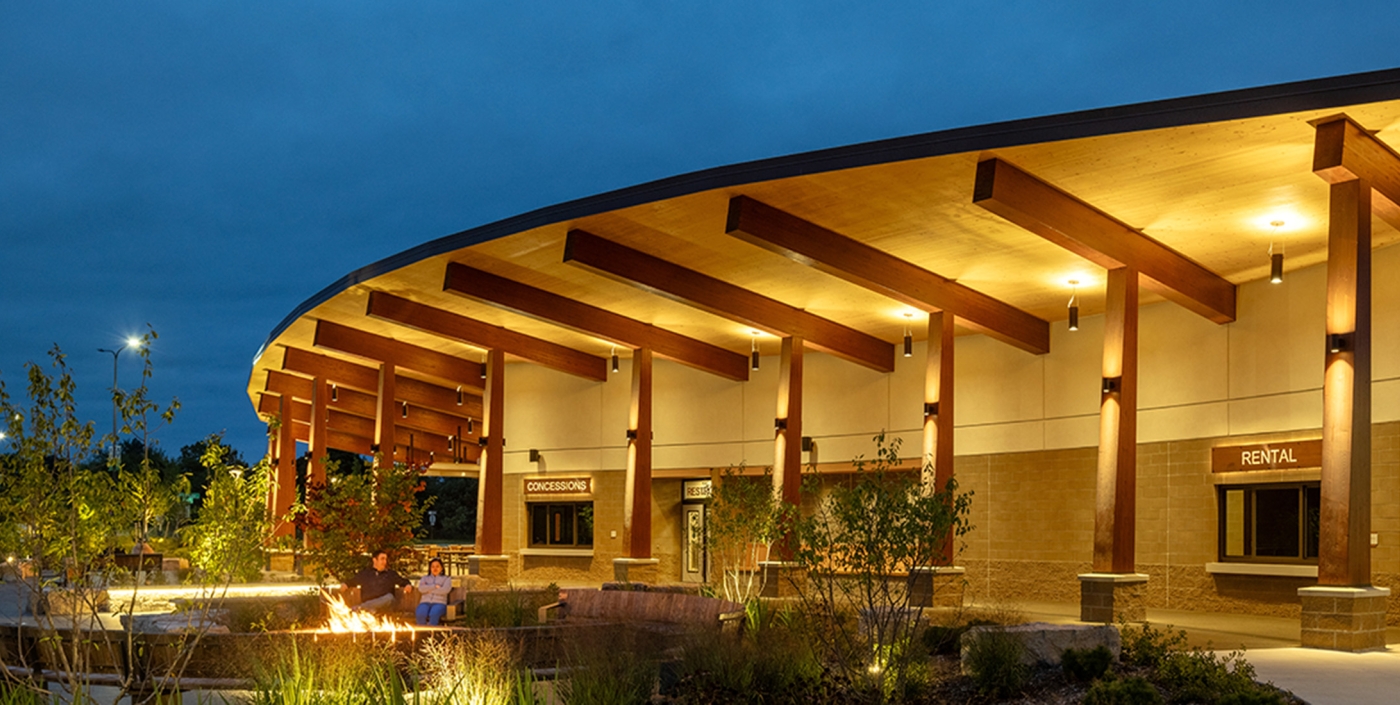 Night shot of mass timber pavilion and seating at Jeanne Stine Park in Troy, Michigan.