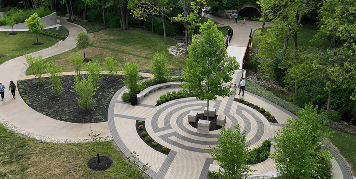 Drone shot of quite reflection space and gently curving landscaped pathways.