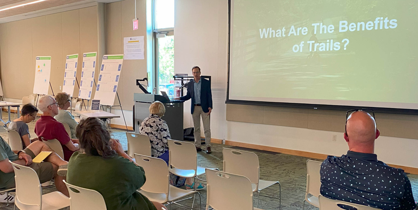 Man presenting at a public meeting on the benefits of trails 