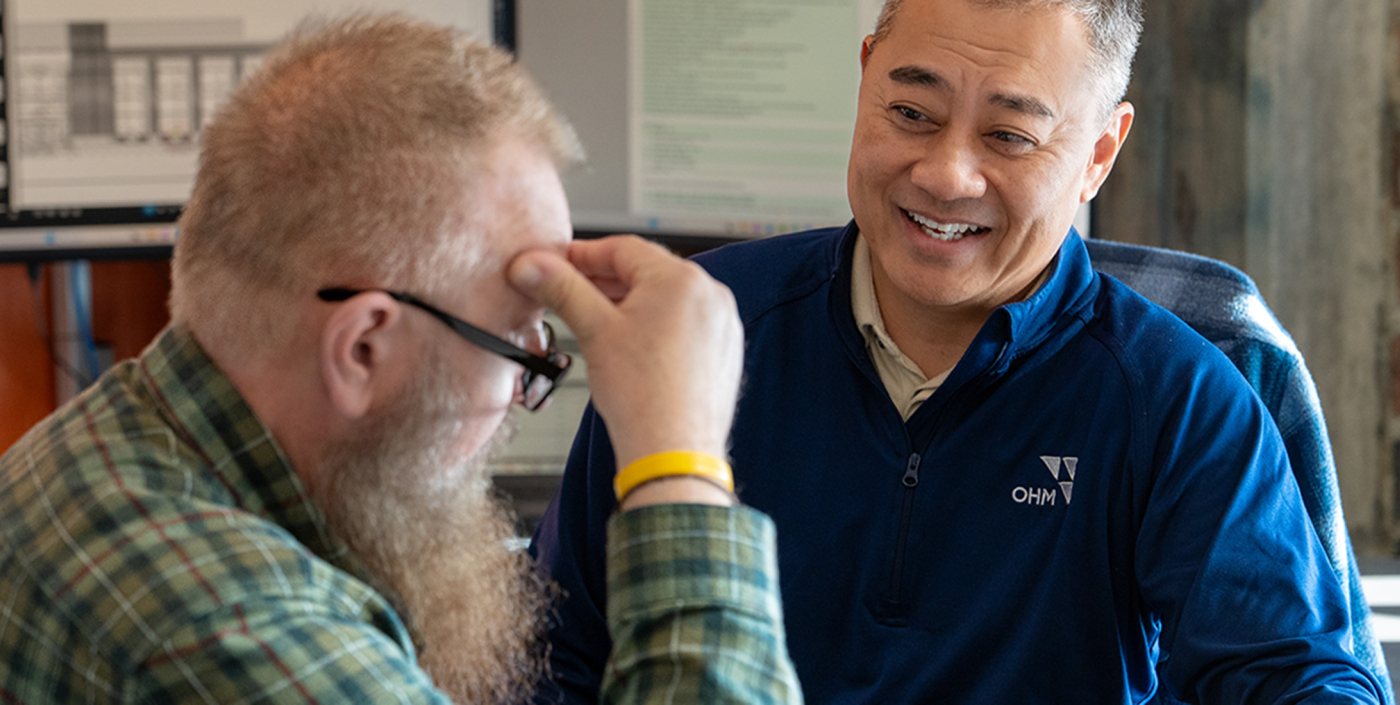 Two OHM Advisors employees talking and smiling.