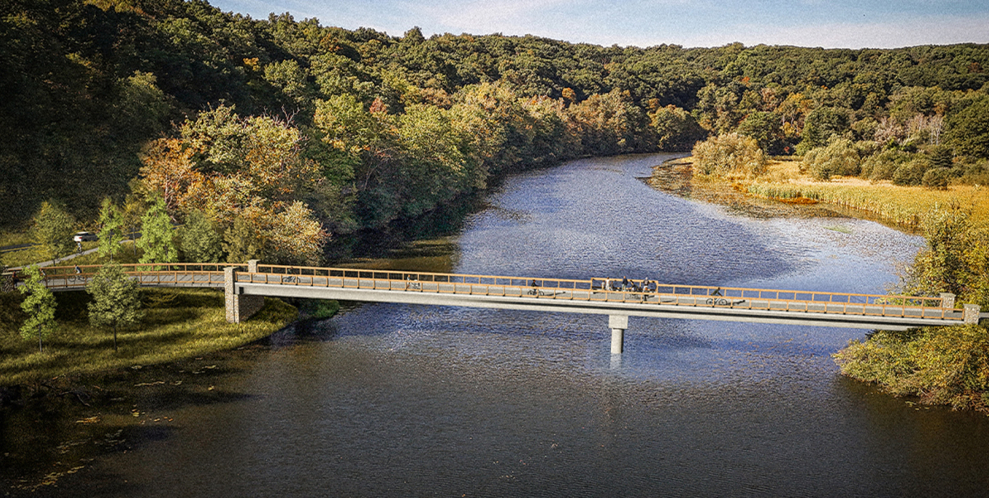 Bridge over large body of water with dense green trees 