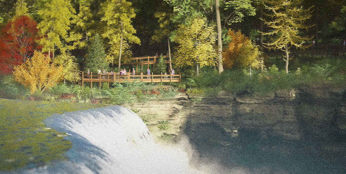 Walking bridge pathway next to a waterfall in a park