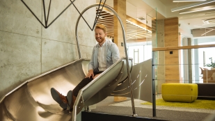 Man sits on slide in office workplace