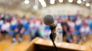 A microphone and podium set up for a speaking engagement.