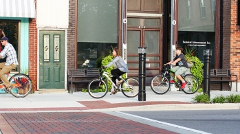 Bicyclists riding on the sidewalk in downtown Fenton.