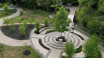 Drone shot of quite reflection space and gently curving landscaped pathways.