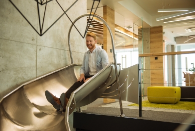 Man sits on slide in office workplace