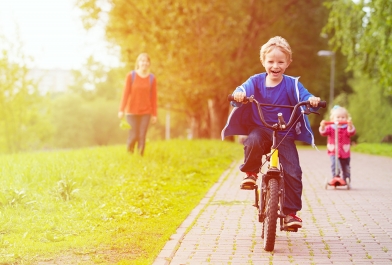 Walkability - boy bike riding down sidewalk