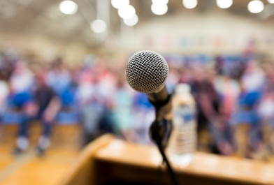 A microphone and podium set up for a speaking engagement.