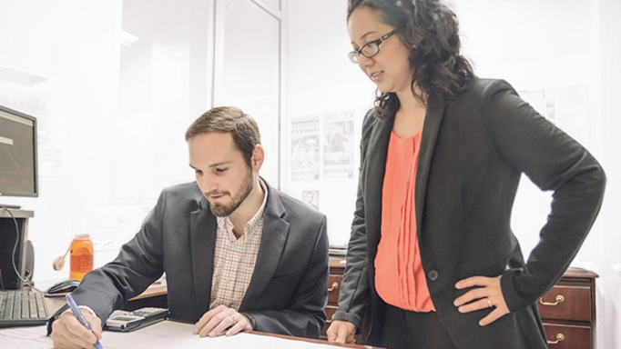 Two young professionals work together on a project at OHM Advisors.