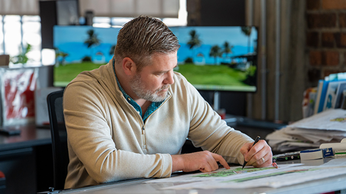 Male employee sketches at a drafting table