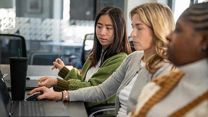 Three young female professionals working on a project